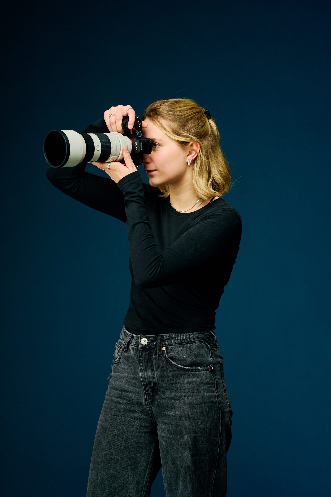 Studio Kreuzkölln Team: Fotografin mit Teleobjektiv